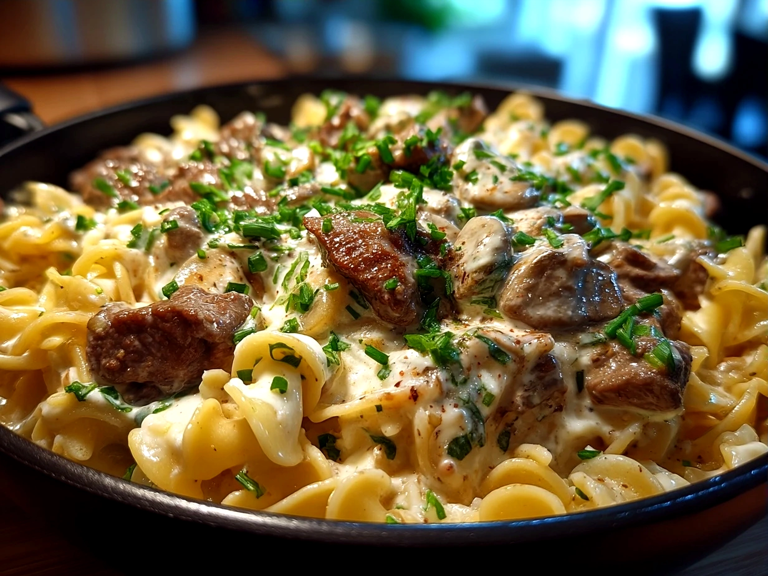 Creamy Beef Stroganoff With Sour Cream served over buttered egg noodles garnished with fresh parsley